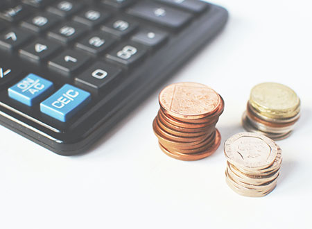 Gold-colored Coins Near Calculator